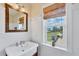 Bathroom featuring a window with a view, white beadboard, white trim and a drop in sink at 1784 Bayshore Dr, Englewood, FL 34223