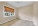 Neutral bedroom featuring a woven shade covered window, carpeted floors and baseboard at 1784 Bayshore Dr, Englewood, FL 34223