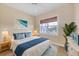 Cozy bedroom featuring a queen bed, window with woven shades, and blue-themed decor at 1784 Bayshore Dr, Englewood, FL 34223