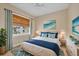 Cozy bedroom featuring a queen bed, window with woven shades, and blue-themed decor at 1784 Bayshore Dr, Englewood, FL 34223