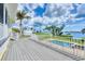 Deck overlooking the pool and waterfront features white railings and stairs leading to the manicured backyard at 1784 Bayshore Dr, Englewood, FL 34223