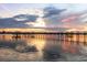 Picturesque sunset view of the dock with calm water reflections creating a serene ambiance at 1784 Bayshore Dr, Englewood, FL 34223