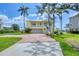 Lovely two-story yellow home with brick driveway, lush lawn, and scenic neighborhood views at 1784 Bayshore Dr, Englewood, FL 34223