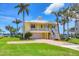 Beautiful two-story yellow home offers a charming covered porch and a well-maintained lawn at 1784 Bayshore Dr, Englewood, FL 34223
