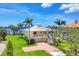 Striking two-story yellow home featuring a well-manicured lawn and inviting brick driveway at 1784 Bayshore Dr, Englewood, FL 34223