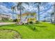 Charming yellow home with well-manicured lawn, tall palm trees, and inviting curb appeal at 1784 Bayshore Dr, Englewood, FL 34223