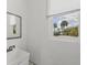 Bright laundry room features a utility sink and a view of palm trees outside the window at 1784 Bayshore Dr, Englewood, FL 34223