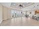 Spacious living room features tile flooring, tray ceiling and doors to the outdoor living space at 1784 Bayshore Dr, Englewood, FL 34223