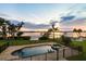 Backyard with swimming pool and spa overlooking waterfront, palm trees, and a black fence at 1784 Bayshore Dr, Englewood, FL 34223