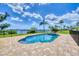 Relaxing pool area, fenced for privacy, with serene water views and lush greenery in the background at 1784 Bayshore Dr, Englewood, FL 34223