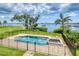 Beautiful pool and spa with brick surround and fenced-in backyard overlooking the bay with a dock at 1784 Bayshore Dr, Englewood, FL 34223