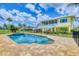 Beautiful pool and spa area with brick surround, complemented by a charming yellow two-story house at 1784 Bayshore Dr, Englewood, FL 34223