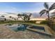 Sparkling pool with attached spa, surrounded by lush landscaping and a serene waterfront backdrop at 1784 Bayshore Dr, Englewood, FL 34223