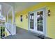 Covered porch featuring double doors, pineapple sconces, and 'Welcome' mat at 1784 Bayshore Dr, Englewood, FL 34223