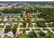Overhead shot of neighborhood, showcasing lush greenery and pond at 1785 Morning Dove Ln, Englewood, FL 34224