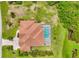 Aerial view of a house with a private screened-in pool and well-manicured yard in a lush setting at 200 Arlington Dr, Placida, FL 33946