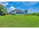 The expansive backyard features a well-manicured lawn and a screened-in lanai at 200 Arlington Dr, Placida, FL 33946