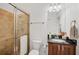 Bright bathroom with a glass-enclosed shower, dark wood vanity, and neutral tile, offering both style and functionality at 200 Arlington Dr, Placida, FL 33946