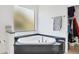 Bathroom with a corner bathtub, frosted windows, and ample shelving in an adjacent walk-in closet at 200 Arlington Dr, Placida, FL 33946