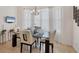 Dining room with modern table and chairs set in front of sheer curtains and a chandelier at 200 Arlington Dr, Placida, FL 33946