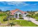 The front exterior of the home features a red tile roof, manicured lawn, and mature palm trees at 200 Arlington Dr, Placida, FL 33946