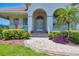 Inviting home entrance with a paver walkway, mature landscaping, and a covered porch at 200 Arlington Dr, Placida, FL 33946