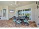 Covered patio area features tile flooring, a ceiling fan, and a dining table with seating for six at 200 Arlington Dr, Placida, FL 33946