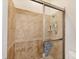 Tiled shower stall featuring glass doors, a rainfall showerhead, and built-in shelving at 200 Arlington Dr, Placida, FL 33946