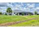 An open backyard showcases a screened lanai and a black chain link fence at 2106 Damascus Ln, Punta Gorda, FL 33983