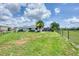 View of a large yard with green grass surrounding a home with a screened in lanai at 2106 Damascus Ln, Punta Gorda, FL 33983