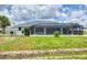 View of a large screened-in lanai, with an expansive yard and a black chain link fence at 2106 Damascus Ln, Punta Gorda, FL 33983