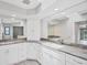Bright bathroom featuring granite countertops, modern white cabinetry, and a large well-lit mirror at 2106 Damascus Ln, Punta Gorda, FL 33983