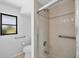 Bright bathroom featuring a tiled shower with glass door and safety grab bars at 2106 Damascus Ln, Punta Gorda, FL 33983