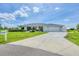 Single-story home featuring a wide driveway, a two-car garage, and well-maintained landscaping at 2106 Damascus Ln, Punta Gorda, FL 33983