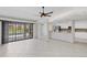 Open-concept living area with tile floors, ceiling fan, and sliding glass doors to the pool area at 2106 Damascus Ln, Punta Gorda, FL 33983
