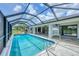 Large screened pool offers clear blue water, landscaped surroundings and an outdoor entertainment area at 2106 Damascus Ln, Punta Gorda, FL 33983
