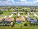 Aerial view of a single-Gathering home with a screened-in pool and nicely landscaped yard in a residential area at 25 Mariner Ln, Rotonda West, FL 33947