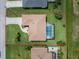 Top-down view of a property featuring a screened lanai, an adjacent outdoor patio, lush lawn, and defined boundaries at 25 Mariner Ln, Rotonda West, FL 33947