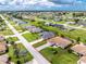 Aerial view showcasing a single-Gathering home with a screened lanai, lush lawn, and neighborhood setting at 25 Mariner Ln, Rotonda West, FL 33947
