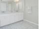 Bathroom featuring dual sinks with marble countertops, decorative lighting and white cabinets at 25 Mariner Ln, Rotonda West, FL 33947