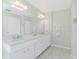 Bathroom featuring dual sinks with marble countertops, decorative lighting and white cabinets at 25 Mariner Ln, Rotonda West, FL 33947