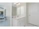 Bright bathroom features a white vanity with built in cabinets, mirror, and a door to the lanai at 25 Mariner Ln, Rotonda West, FL 33947