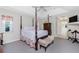 This bedroom has a four-poster bed with gray carpet and a view of an ensuite bathroom at 25 Mariner Ln, Rotonda West, FL 33947
