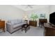 Cozy bedroom includes a love seat, ceiling fan, and a bright window with view of the yard at 25 Mariner Ln, Rotonda West, FL 33947