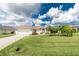 Charming single-story home with a well-manicured lawn, palm trees, and an attached two-car garage at 25 Mariner Ln, Rotonda West, FL 33947