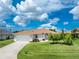 A charming home with a well-manicured lawn and garden, showcasing the property's curb appeal and inviting exterior at 25 Mariner Ln, Rotonda West, FL 33947