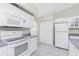 Kitchen featuring modern appliances, white cabinets and tiled floors at 25 Mariner Ln, Rotonda West, FL 33947