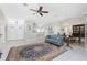 A bright and airy living room featuring a ceiling fan and an open layout that leads to the kitchen and dining areas at 25 Mariner Ln, Rotonda West, FL 33947