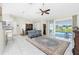 A spacious living room with tile floors, a ceiling fan, and access to the pool area through sliding glass doors at 25 Mariner Ln, Rotonda West, FL 33947