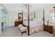 Main bedroom with a four-poster bed, walk-out to pool, and ample natural light at 25 Mariner Ln, Rotonda West, FL 33947